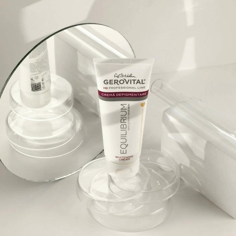 Gerovital Equilibrium Brightening Cream tube on clear dish beside mirror