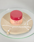 Aslavital Collagen Anti-Wrinkle and Firming Cream jar on cracked clay in a glass dish