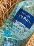 Close-up of Gerovital H3 Classic Cornflower and Juvinity Micellar Water bottle on wood shavings