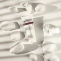 Gerovital Equilibrium Brightening Cream tube among white petals in sunlight