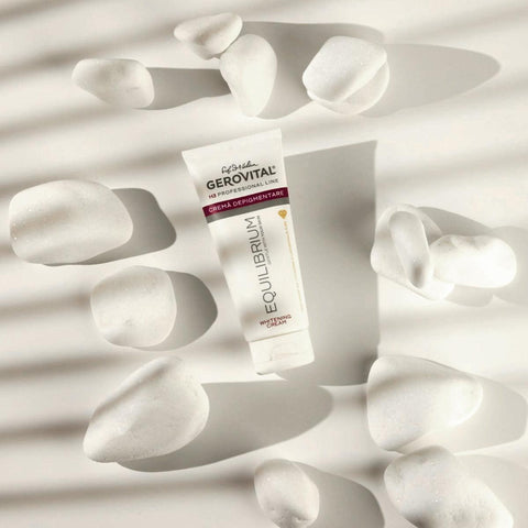 Gerovital Equilibrium Brightening Cream tube among white petals in sunlight