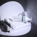 Gerovital Equilibrium Spa Relax Massage Cream bottle lying beside rolled towels