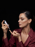 Woman dispensing Gerovital H3 Evolution hyaluronic acid serum onto her fingertip