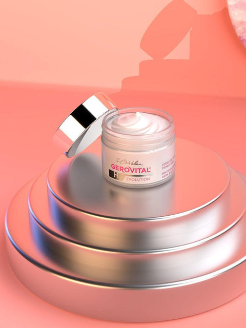 Open Gerovital Dark Spots Corrector cream jar on tiered silver stands against a pink background