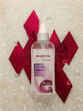 Gerovital H3 Evolution Micellar Water bottle covered in droplets against red geometric shapes
