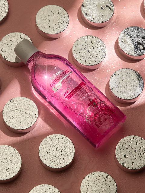 Gerovital Wild Rose Oil Micellar Water bottle among silver discs covered in water droplets