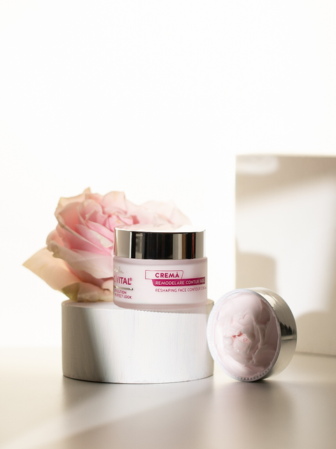Gerovital Reshaping Face Contour Cream jar on a white stand beside a flower and cream-filled silver lid