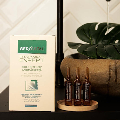 Gerovital Hair Expert Anti-Dandruff Ampoules box and three ampoules beside a plant