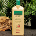 Gerovital Hair Expert Anti Hair Loss Shampoo bottle beside wood and green foliage