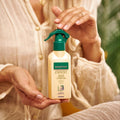 Person holding a Gerovital Hair Expert Keratin Nutritive Balm spray bottle