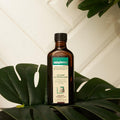 Gerovital Hair Expert Petroleum Regenerating Lotion bottle surrounded by green leaves