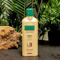 Gerovital Hair Expert Volume Shampoo with Wheat Protein bottle beside wood and green plants