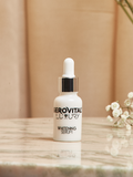 Gerovital Luxury brightening serum bottle beside white flowers