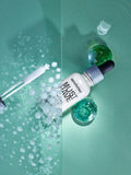 Gerovital Must Have firming serum bottle and dropper with laboratory flasks on green