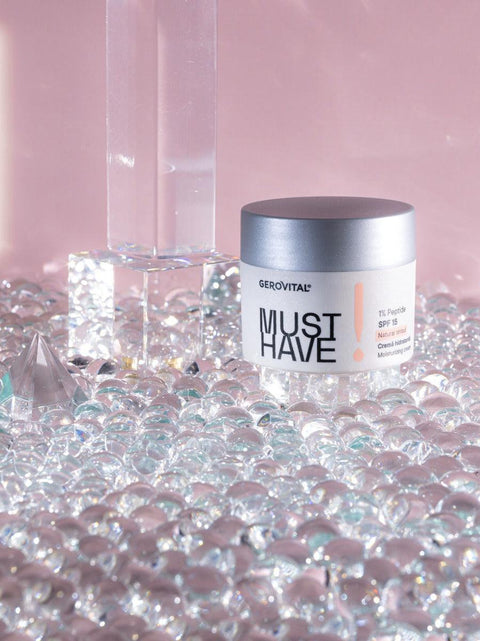 Gerovital Must Have Moisturising Cream SPF 15 jar among clear decorative crystals on pink